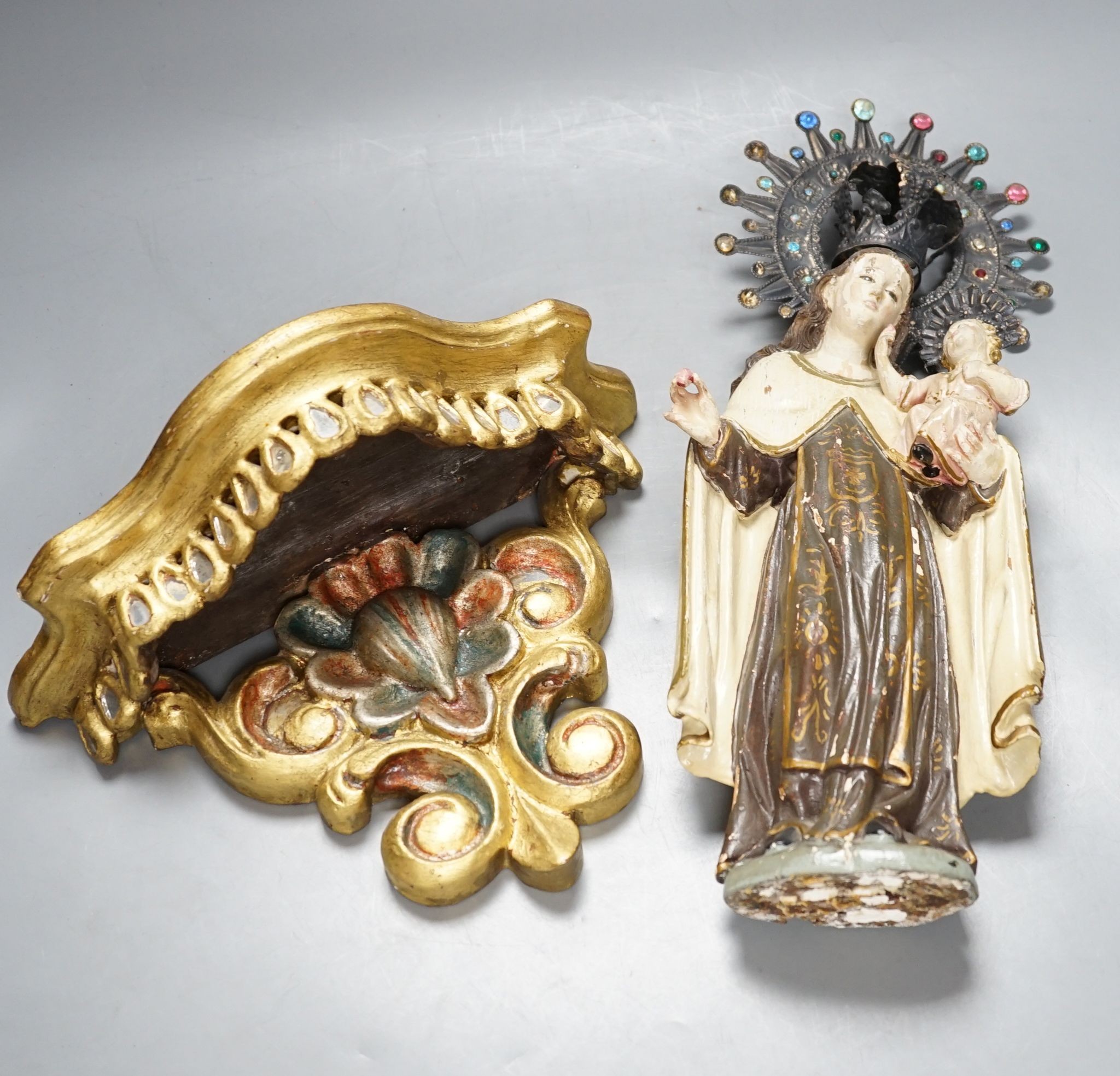 An ornate South American Madonna and child with a metal crown and halo, standing on a carved bracket, 39cm